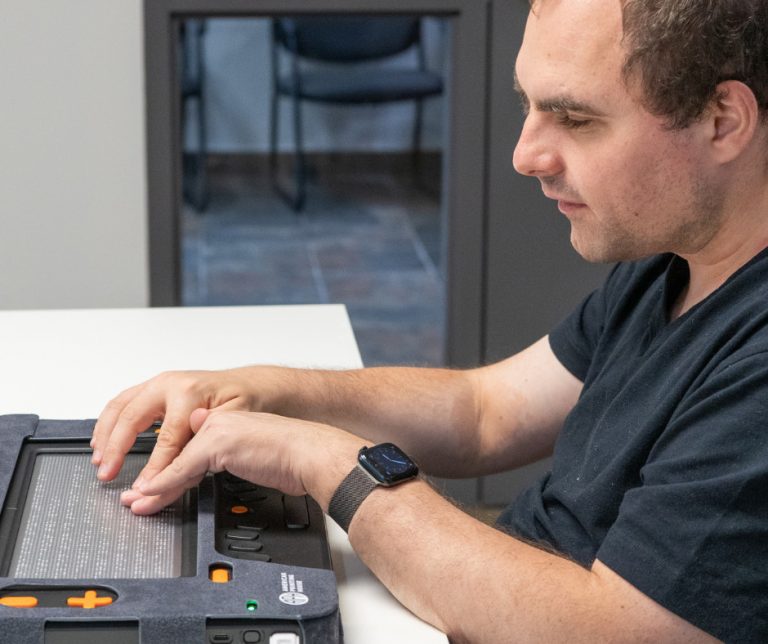 Image of a focused man using the Monarch device to read his emails.