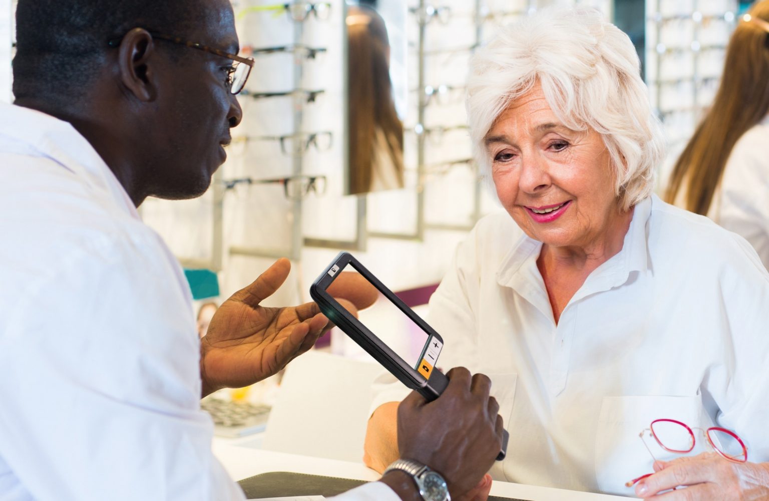 Image of a person with an eye care professional, who demonstrates the functions of explorer 5.